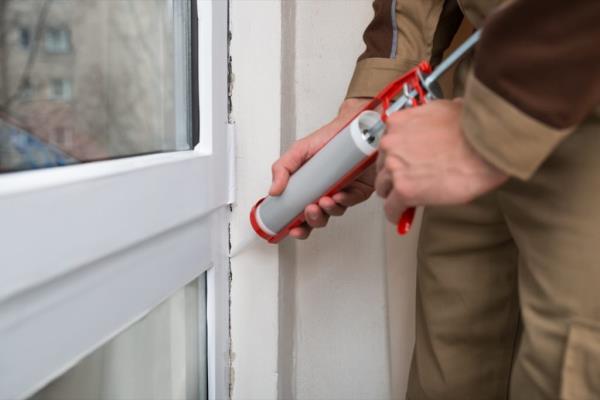 Person Sealing Cracks in Home